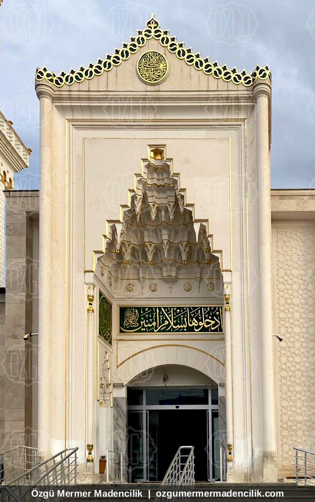 Altın taçlı mukarnaslı beyaz mermer cami giriş kapısı