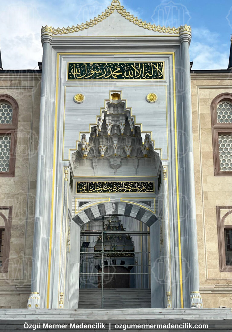 Taş cephede beyaz mermer mukarnaslı cami taç kapısı