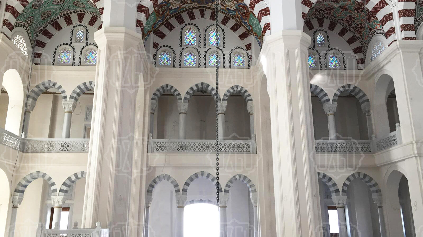 Ablak kemerli revaklarıyla beyaz mermer cami iç mekânı